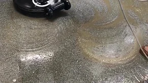 Scrubbing a concrete floor with specialized industrial equipment.