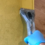 Upholstery cleaning process on a yellow chair.