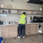 Triple Star Commercial Cleaning staff sanitizing an office kitchen counter, ensuring a hygienic and safe workspace in Auckland and Christchurch.