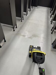 Commercial bathroom floor cleaning and builders cleaning in Christchurch using professional scrubber equipment by Triple Star Commercial Cleaning.