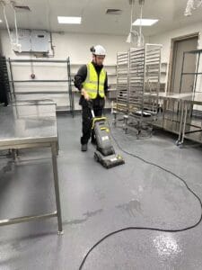 Commercial kitchen floor scrubbing and builders cleaning in Christchurch using professional floor scrubber equipment by Triple Star Commercial Cleaning.