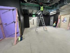 High-level builders cleaning in Christchurch using ladders and professional equipment during a commercial construction cleaning project by Triple Star Commercial Cleaning.