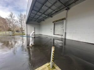 Commercial pressure washing of a warehouse loading dock and exterior concrete surface in Christchurch by Triple Star Commercial Cleaning.