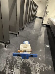 Commercial bathroom floor scrubbing and builders cleaning in Christchurch using professional floor cleaning equipment by Triple Star Commercial Cleaning.