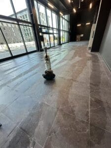 Builders cleaning of tiled flooring at One New Zealand Stadium, Christchurch, using commercial floor scrubbing equipment.